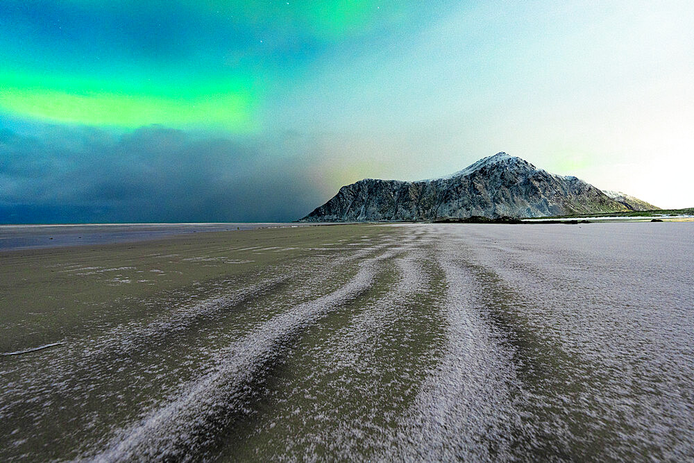 Frozen sand of Skagsanden beach under northern lights (aurora borealis) in winter, Flakstad, Nordland county, Lofoten Islands, Norway, Scandinavia, Europe