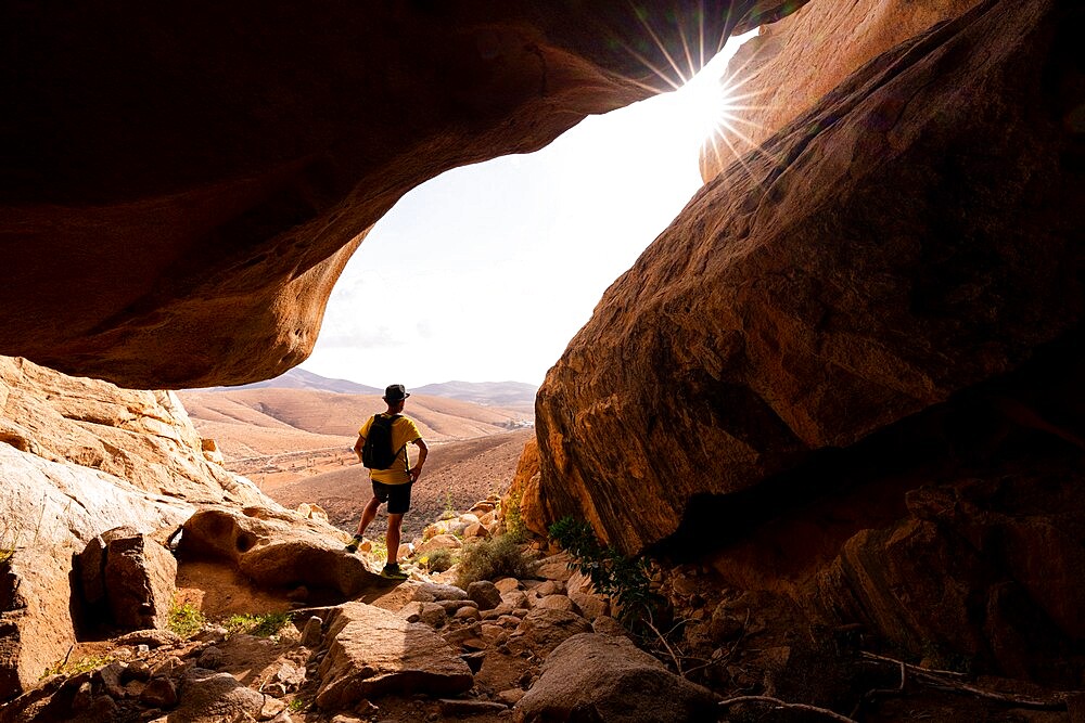 Man enjoying the view standing inside the sandstone canyons, Barranco de las Penitas, Fuerteventura, Canary Islands, Spain, Atlantic, Europe