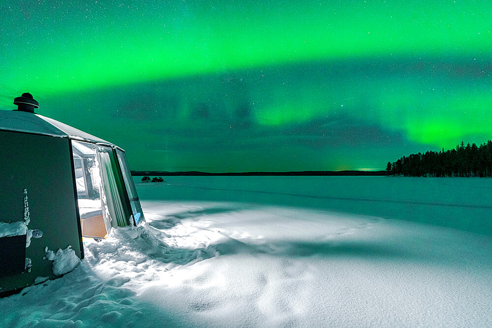 Illuminated empty igloo in the frozen landscape under Aurora Borealis (Northern Lights), Jokkmokk, Lapland, Sweden, Scandinavia, Europe