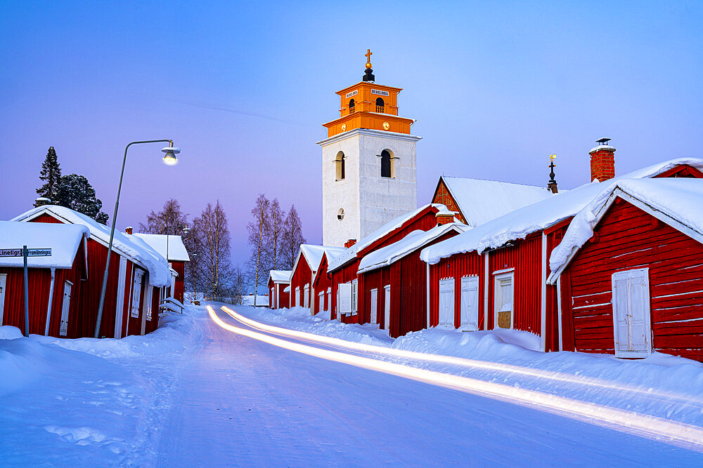 Car trails lights on the icy road crossing the medieval Gammelstad Church Town covered with snow, UNESCO World Heritage Site, Lulea, Sweden, Scandinavia, Europe