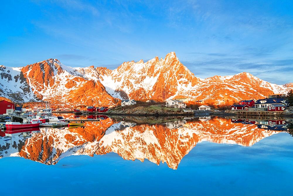 Majestic mountains and fishing village reflected in the cold sea, Ballstad, Vestvagoy, Lofoten Islands, Norway