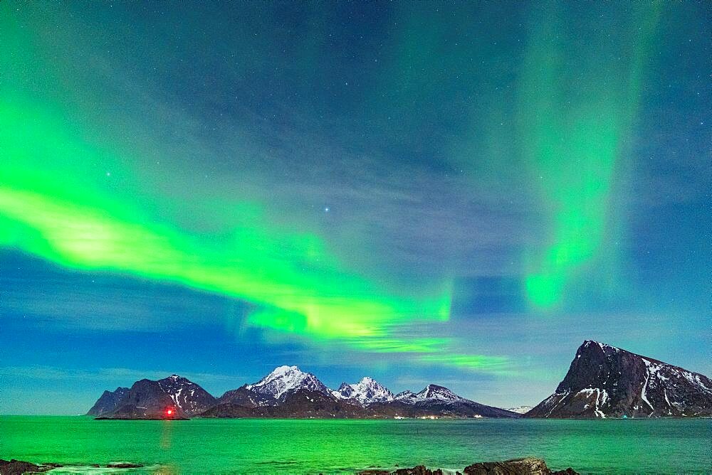 Starry sky with Northern Lights over mountains and cold sea, Myrland, Leknes, Vestvagoy, Lofoten Islands, Norway