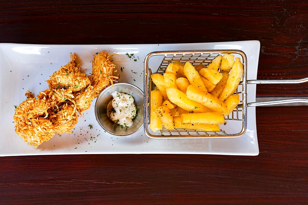 Overhead view of crunchy fried coconut prawns with french fries in a tray, Antigua, Leeward Islands, Caribbean, West Indies