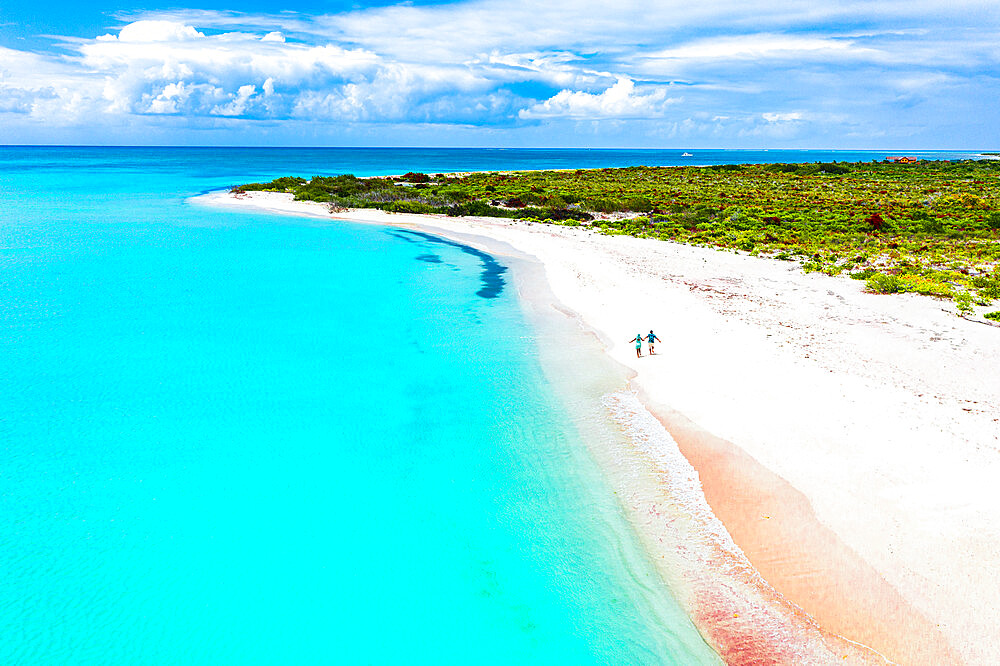 Man and woman running happy hand in hand on idyllic beach during honeymoon, overhead view, Barbuda, Antigua and Barbuda, West Indies, Caribbean, Central America