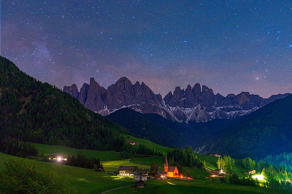 The fairy tale alpine village of Santa Magdalena and Odle group under the starry night sky, Funes Valley, Dolomites, South Tyrol, Italy, Europe