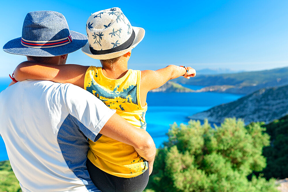 Happy father with cute little boy admiring the sea surrounding Myrtos beach from coastline, Kefalonia, Ionian Islands, Greek Islands, Greece, Europe