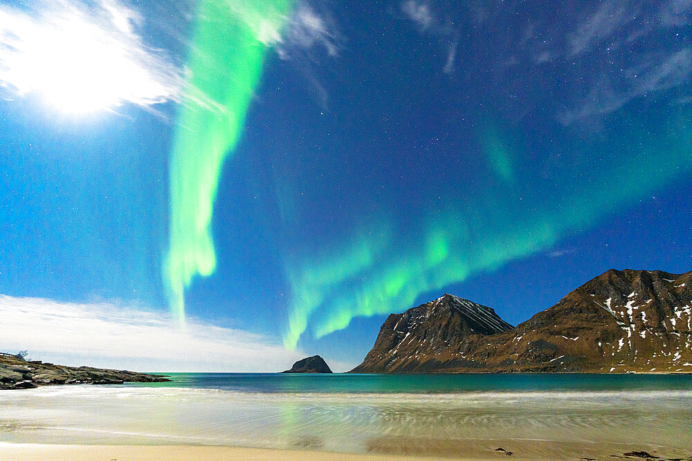 Waves of the icy sea lit by moon and green lights of Aurora Borealis (Northern Lights), Haukland beach, Leknes, Lofoten Islands, Norway, Scandinavia, Europe