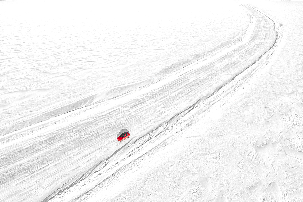 Aerial view of car traveling on empty ice road on the frozen sea, Lulea, Norrbotten County, Lapland, Sweden, Scandinavia, Europe