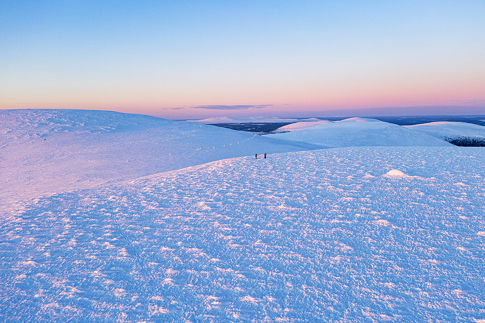 Aerial view of hikers enjoying cross-country skiing at sunset, Pallas-Yllastunturi National Park, Muonio, Lapland, Finland, Europe