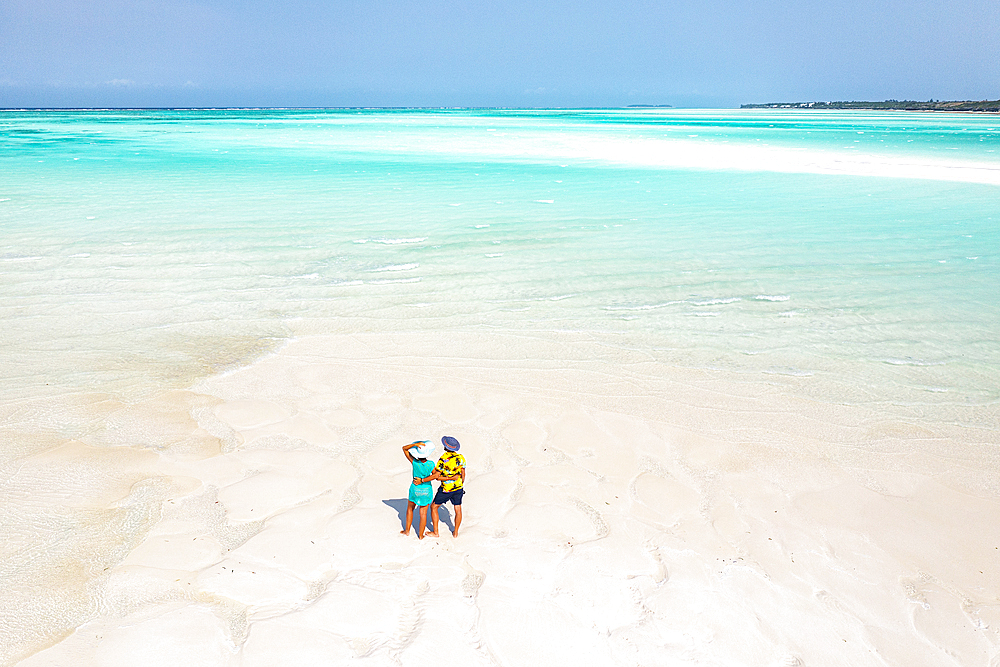 Cheerful man and woman embracing on idyllic tropical beach, overhead view, Nungwi, Zanzibar, Tanzania, East Africa, Africa