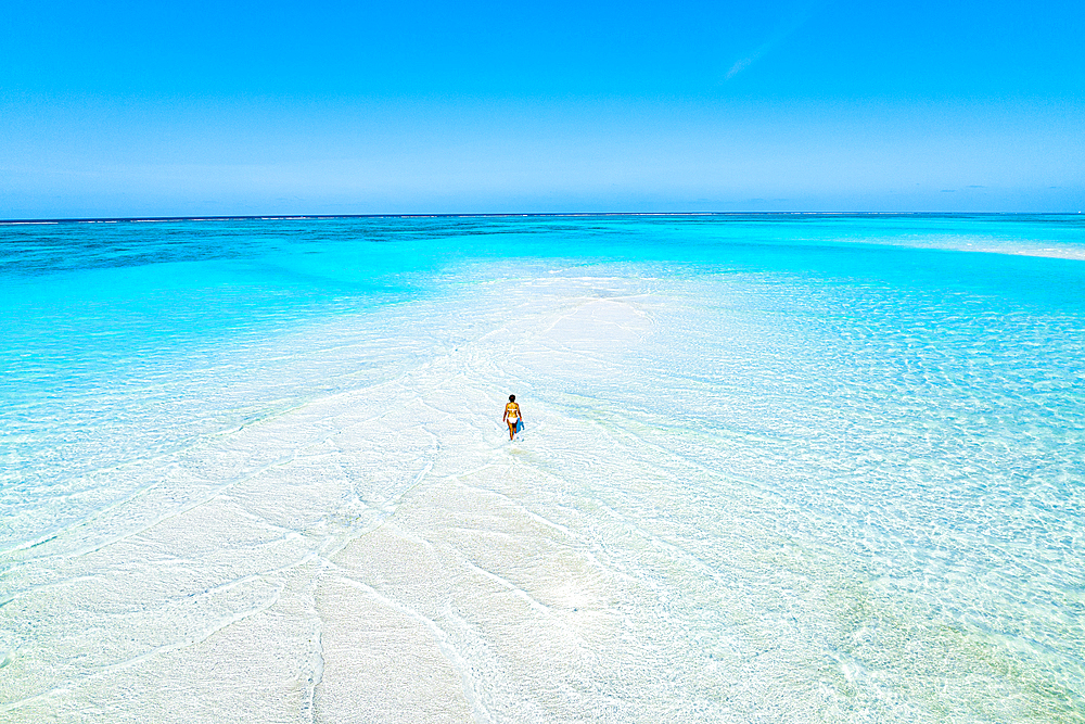 Aerial view of woman bathing in the transparent sea in the scenic sandbanks, Nungwi, Zanzibar, Tanzania, East Africa, Africa