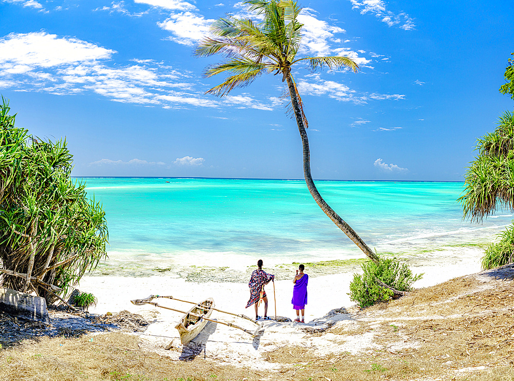 Man and woman of Maasai tribe admiring the turquoise lagoon standing under a palm tree, Zanzibar, Tanzania, East Africa, Africa