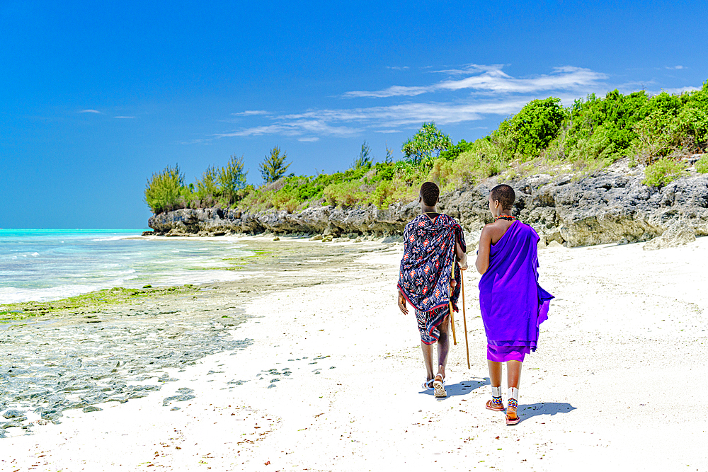 Beautiful Maasai woman with man walking on empty beach, Zanzibar, Tanzania, East Africa, Africa