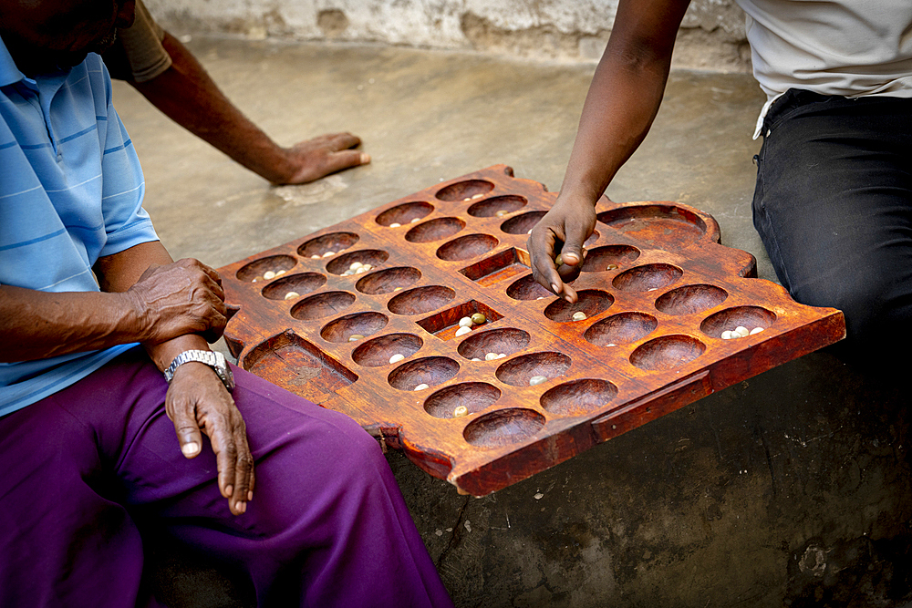 Men playing the famous Bao board game in the street, Stone Town, Zanzibar, Tanzania, East Africa, Africa