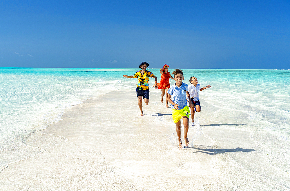 Cheerful parents with sons having fun running on an idyllic empty beach, Zanzibar, Tanzania, East Africa, Africa