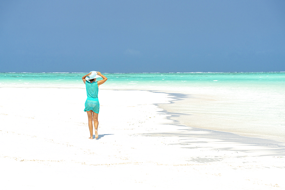 Woman walking on idyllic empty beach, Zanzibar, Tanzania, East Africa, Africa