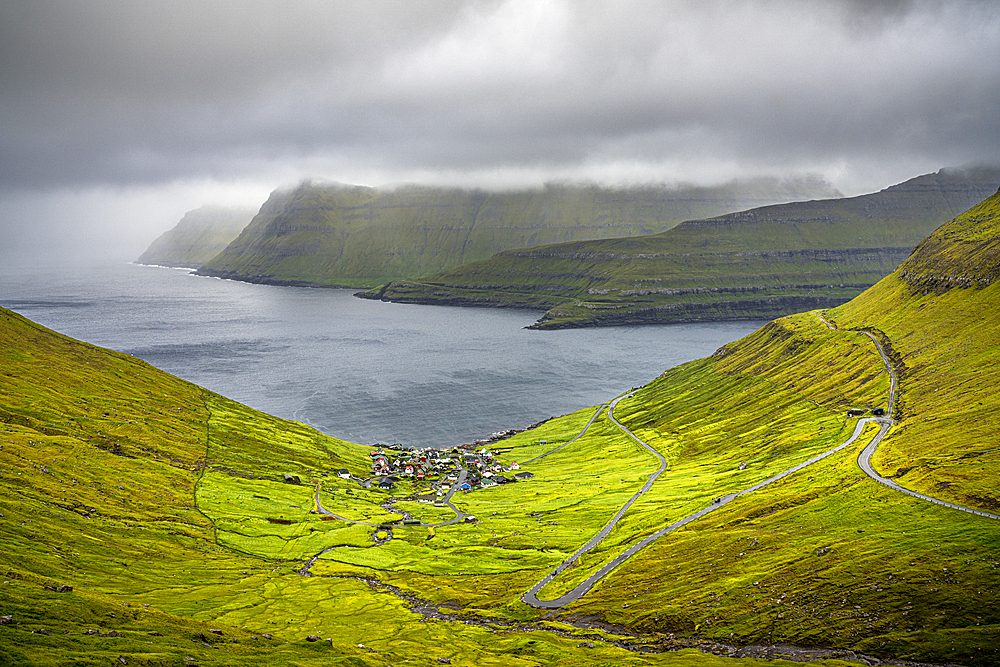 Storm clouds over the coastal village of Funningur along the fjord, Eysturoy Island, Faroe Islands, Denmark, Europe