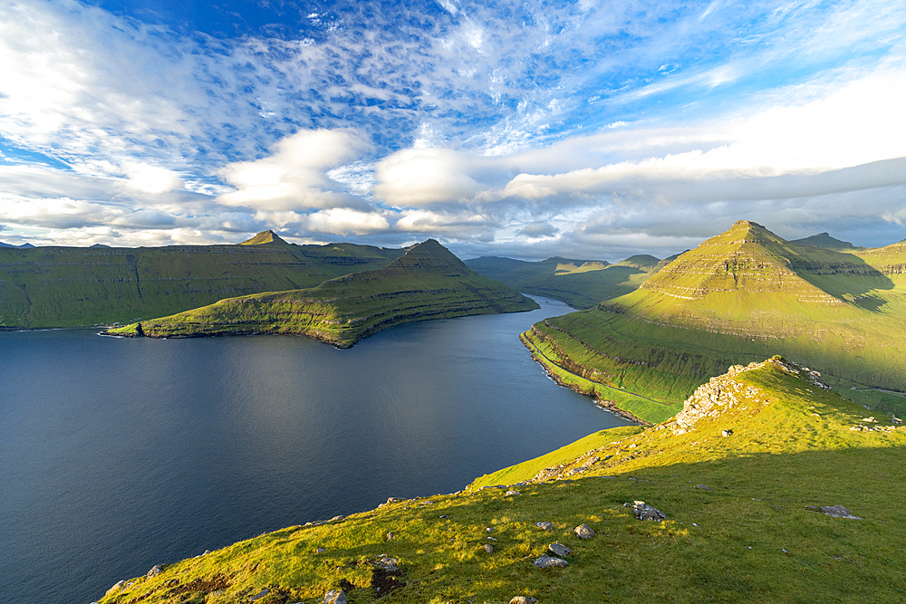 Clouds in the summer sky over mountains along a fjord, Eysturoy Island, Faroe Islands, Denmark, Europe