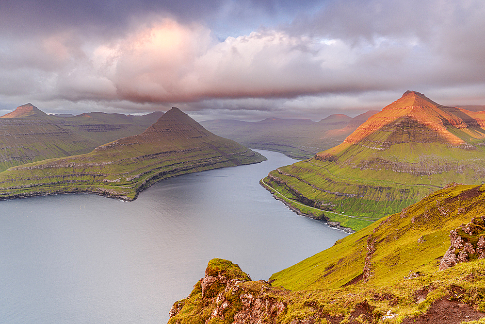 Pink sunrise over mountains and cliffs along Funningur fjord, Eysturoy Island, Faroe Islands, Denmark, Europe