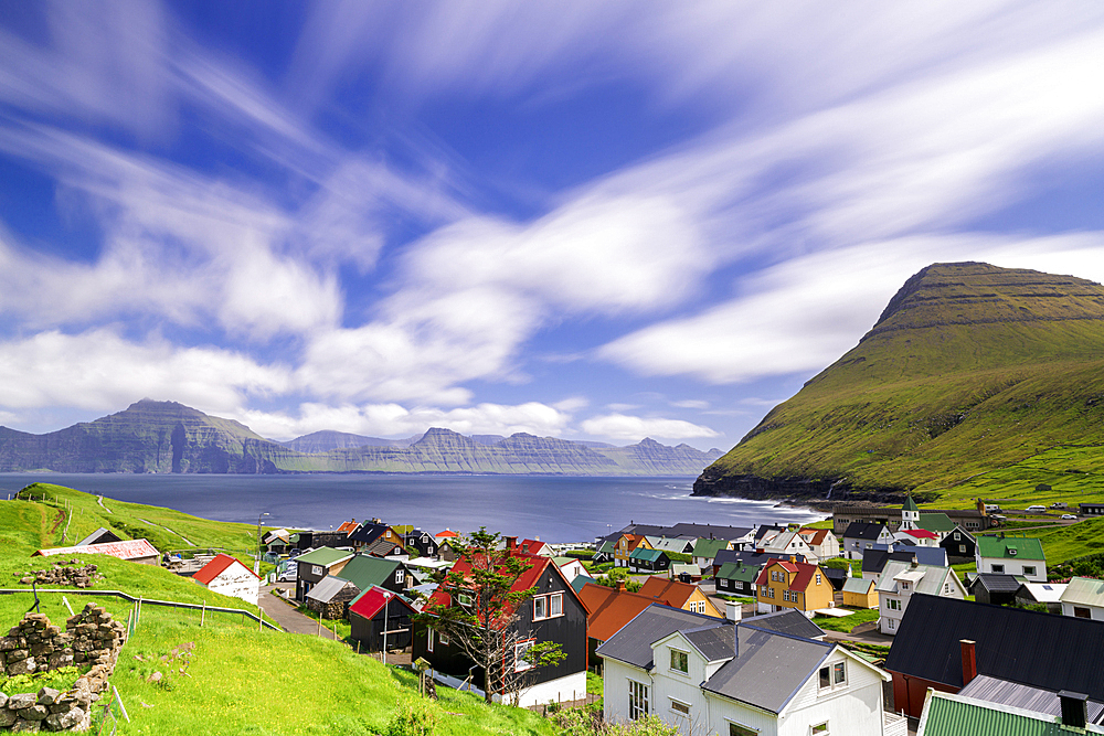 Fluffy clouds in the summer sky over the traditional houses of Gjogv, Eysturoy Island, Faroe Islands, Denmark, Europe