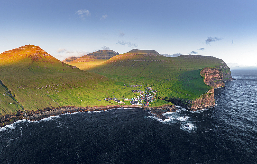 Aerial panoramic view of the village of Gjogv on cliffs washed by the ocean, Eysturoy Island, Faroe Islands, Denmark, Europe