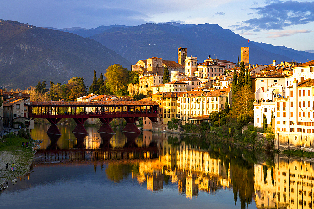 Sunset over the iconic Ponte Vecchio bridge reflected in river Brenta, Bassano Del Grappa, Vicenza province, Veneto, Italy, Europe