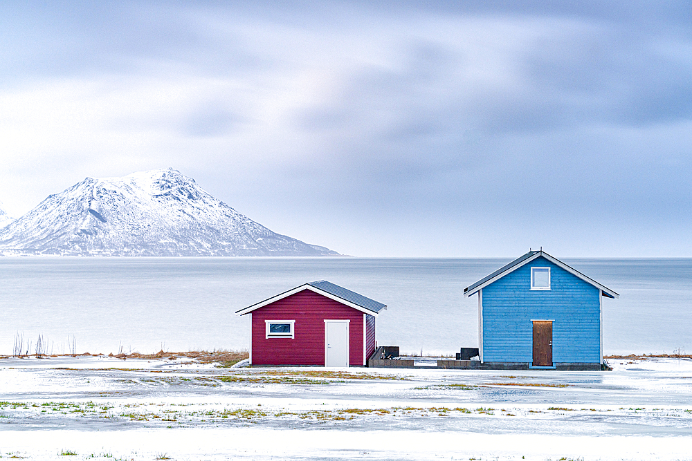 Traditional rorbu cabins overlooking the frozen sea, Troms county, Norway, Scandinavia, Europe