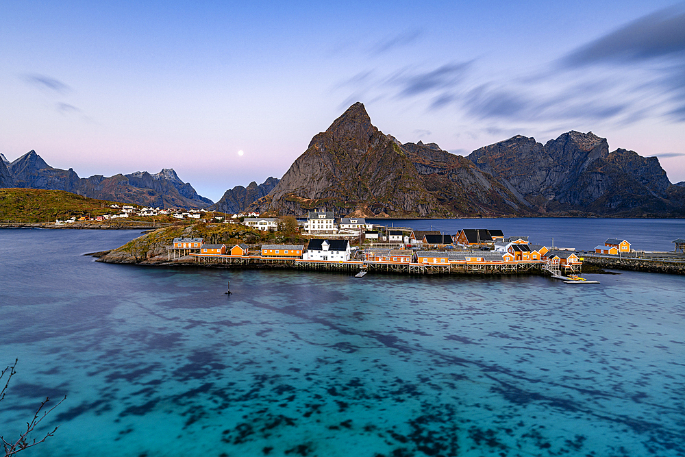 Sunrise over Olstind mountain and fishing village of Sakrisoy overlooking the cold blue sea, Lofoten Islands, Nordland, Norway, Scandinavia, Europe