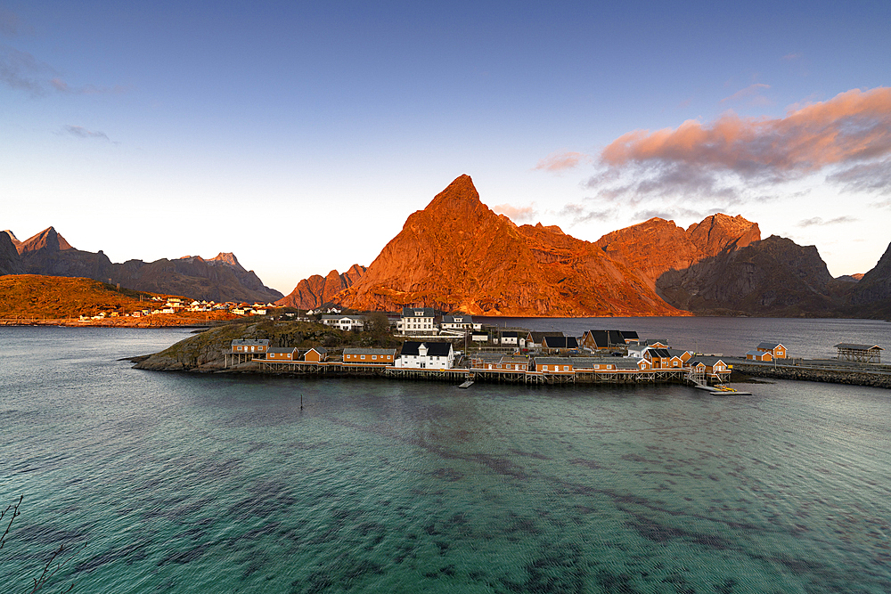 Sunrise over Olstind mountain and fishing village of Sakrisoy overlooking the crystal sea, Lofoten Islands, Nordland, Norway, Scandinavia, Europe