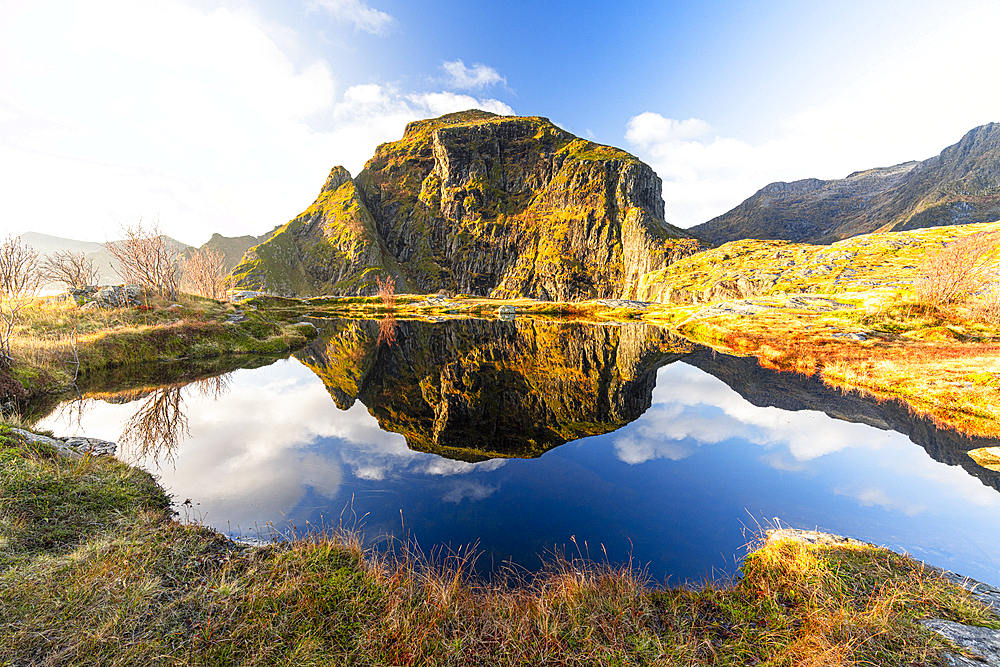 Mountains mirrored in the pristine blue water in autumn, A i Lofoten, Moskenes, Lofoten Islands, Nordland, Norway, Scandinavia, Europe