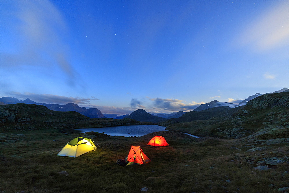 The soft lights of the tents light up dusk, Minor Valley, High Valtellina, Livigno, Lombardy, Italy, Europe