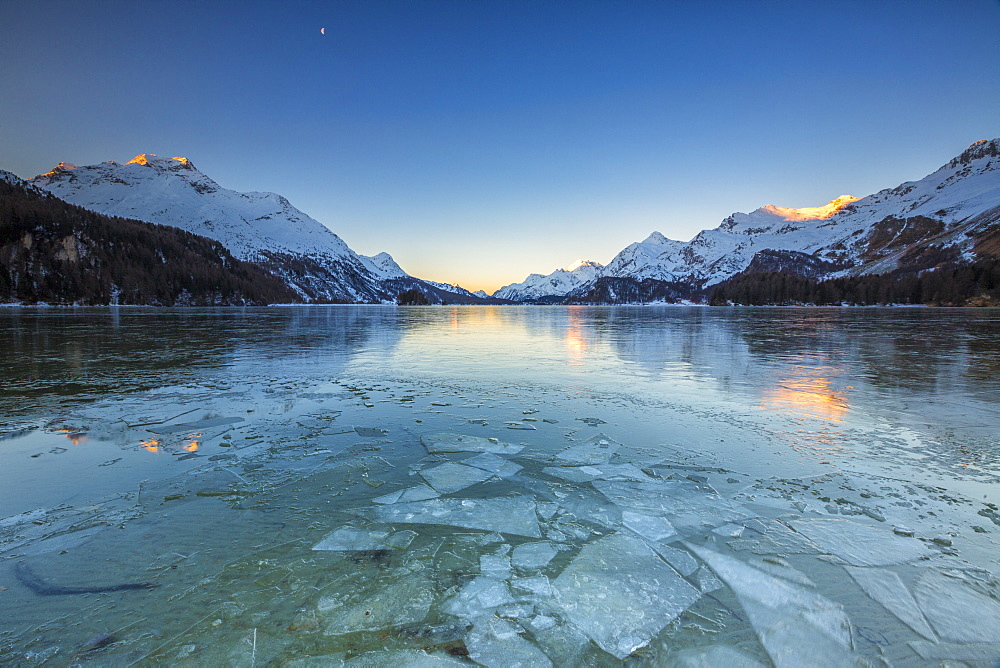 Sheets of ice on the surface of Lake Sils in a cold winter morning at dawn, Engadine, Canton of Graubunden, Switzerland, Europe