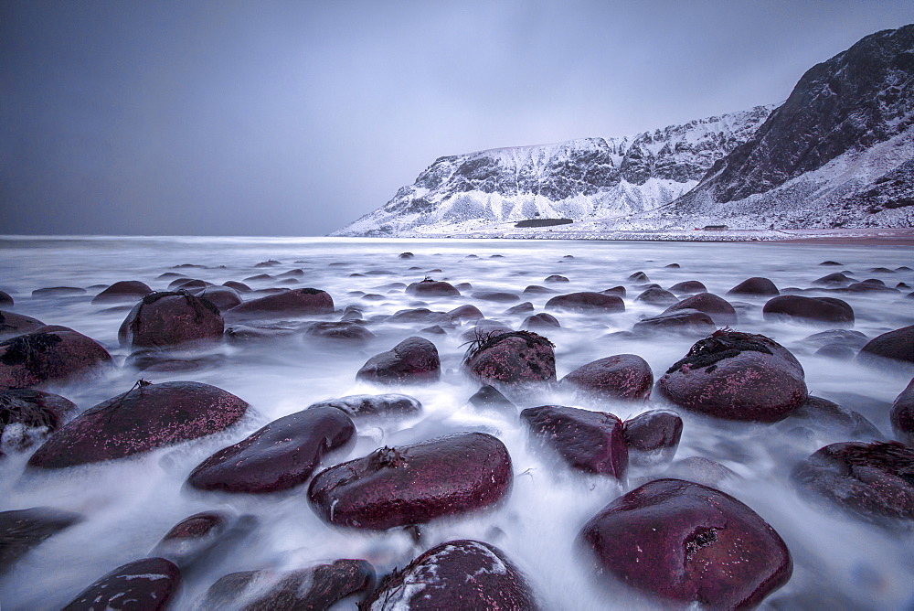 Rocks on the beach modeled by the wind surround the icy sea, Unstad, Lofoten Islands, Arctic, Norway, Scandinavia, Europe