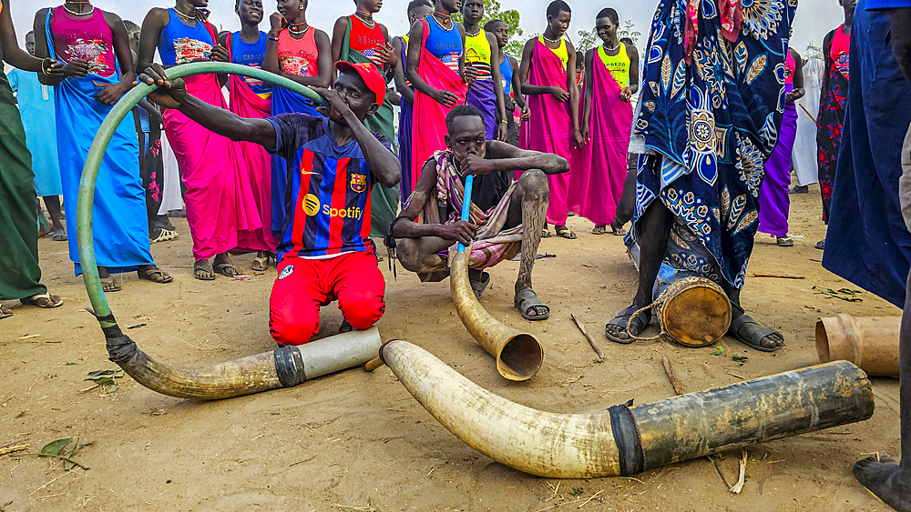 Men making music from cow horns at a traditional Dinka wedding, Bor, central region, South Sudan, Africa