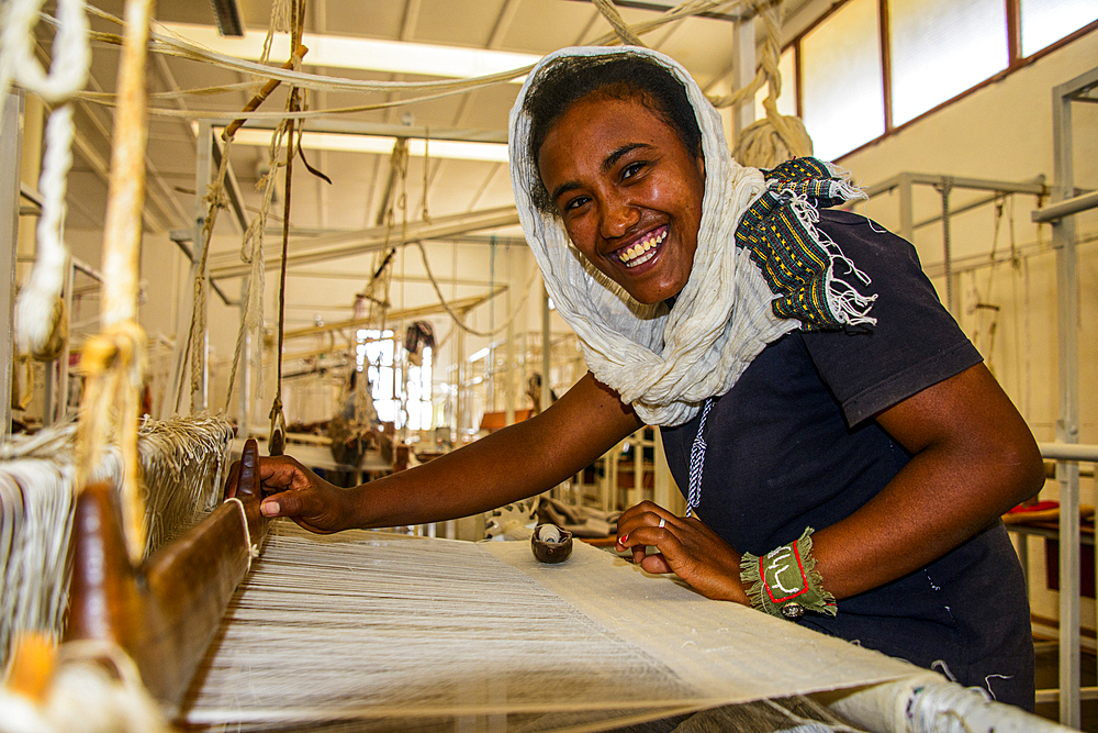 Friendly woman working on a hand weaving loom on a social project in the highlands of Eritrea, Africa