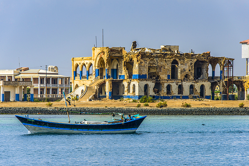 Fishing boat floating in front of the bombed government palace in the the old town of Massawa, Eritrea, Africa