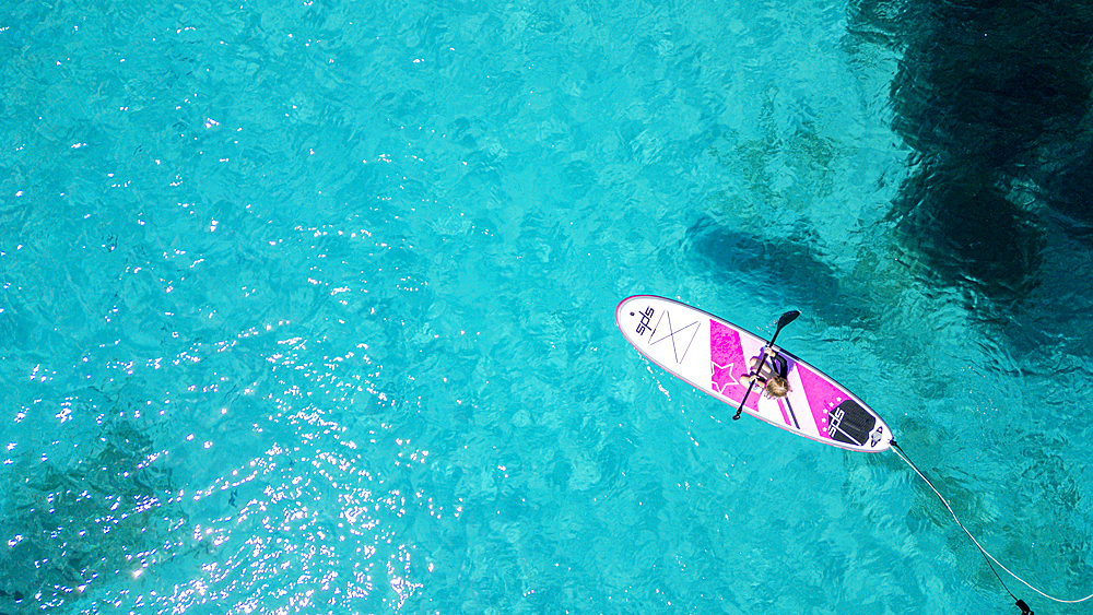 Aerial of a young girl paddling on a SUP on the Formentor Peninsula, Mallorca, Balearic islands, Spain, Mediterranean, Europe