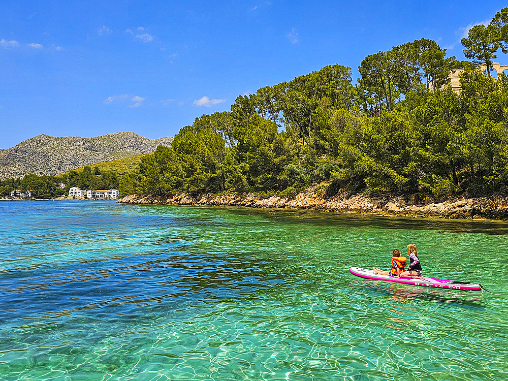 Girln on a SUP in the turquoise waters of the Formentor Peninsula, Mallorca, Balearic islands, Spain, Mediterranean, Europe