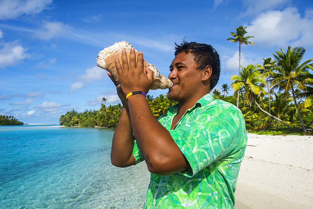 Local man blowing a huge conch, Aitutaki lagoon, Rarotonga and the Cook Islands, South Pacific, Pacific