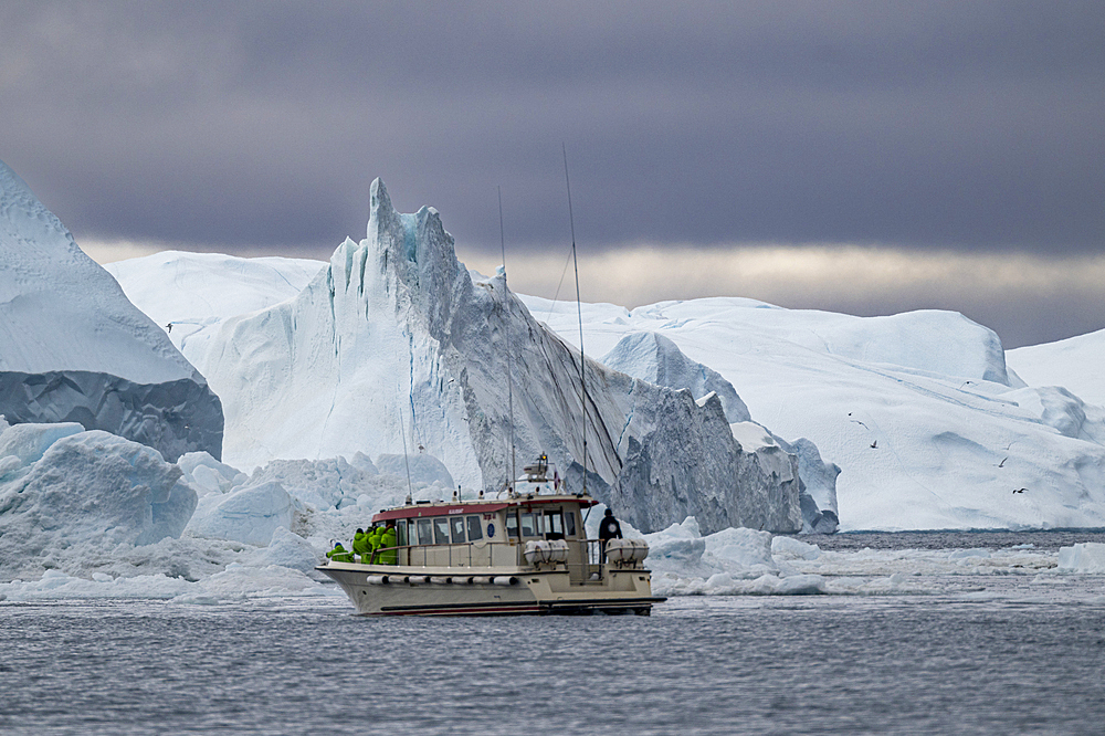 Little boat between the icebergs of the Ilulissat Icefjord, UNESCO World Heritage Site, Western Greenland, Denmark, Polar Regions