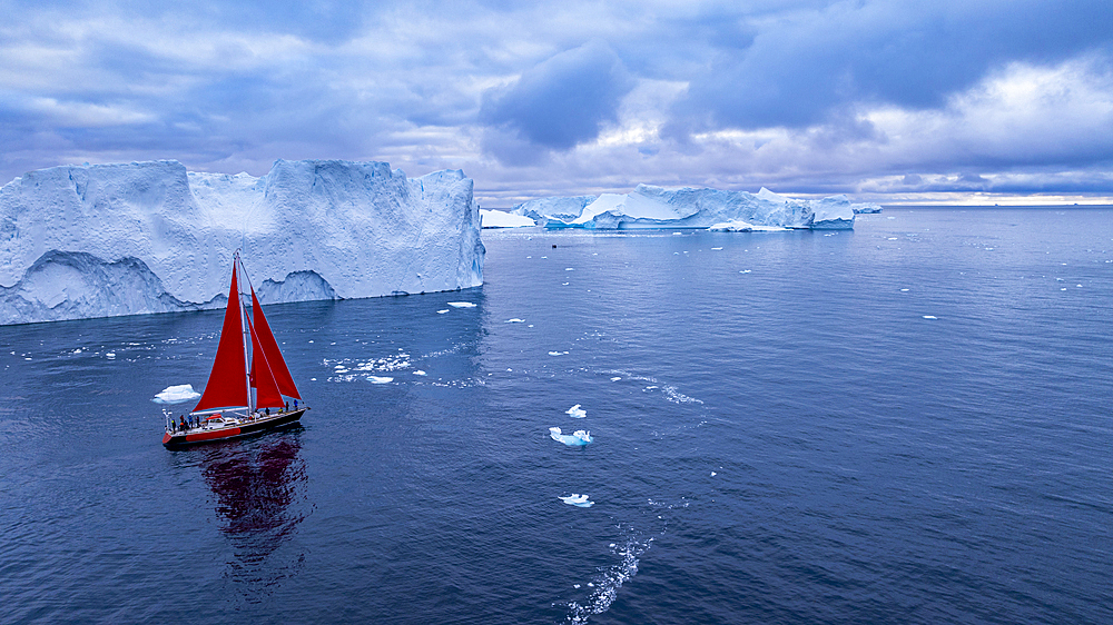 Aerial of a red sailing boat in the Ilulissat Icefjord, UNESCO World Heritage Site, Western Greenland, Denmark, Polar Regions