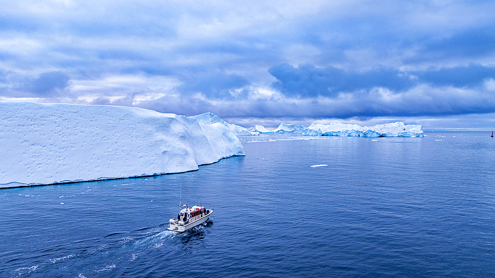 Aerial of a boat between the icebergs of the Ilulissat Icefjord, UNESCO World Heritage Site, Western Greenland, Denmark, Polar Regions