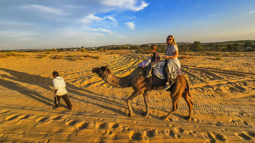 Family riding on camels, Desert camp, Osian, India