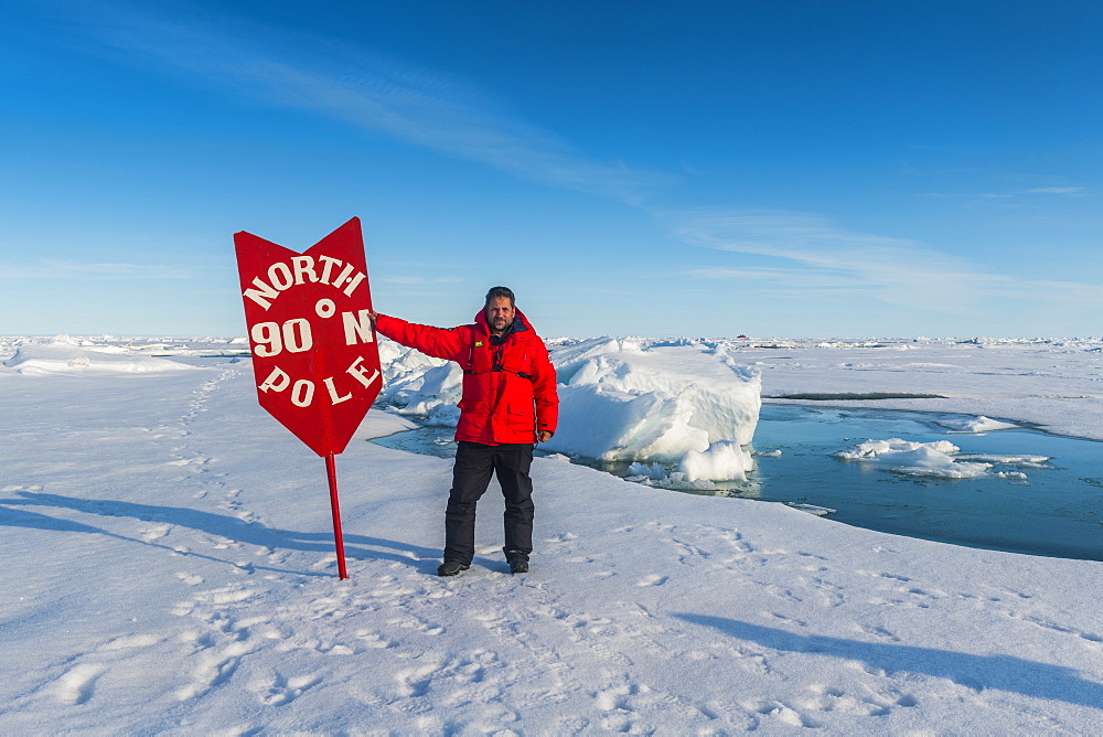 Man standing by sign at North Pole, Arctic