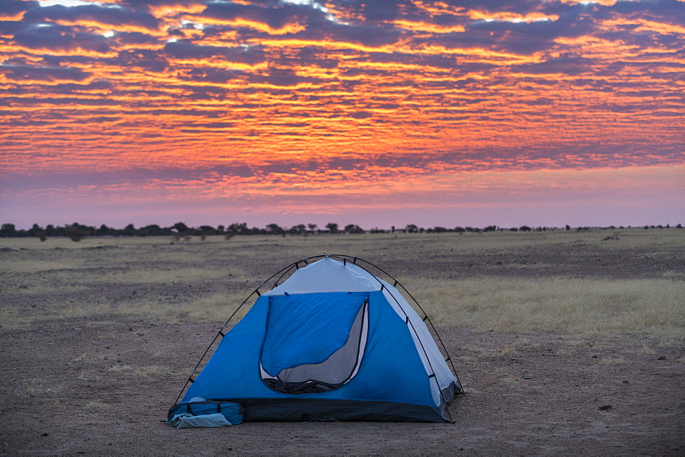 Camping under a dramatic morning sky in the Sahel, Chad, Africa