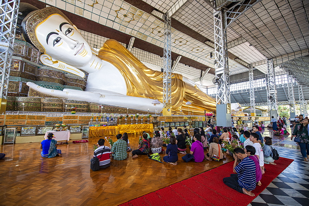 Pilgrims praying before the reclining Buddha, Shwethalyaung Temple, Bago, Myanmar (Burma), Asia