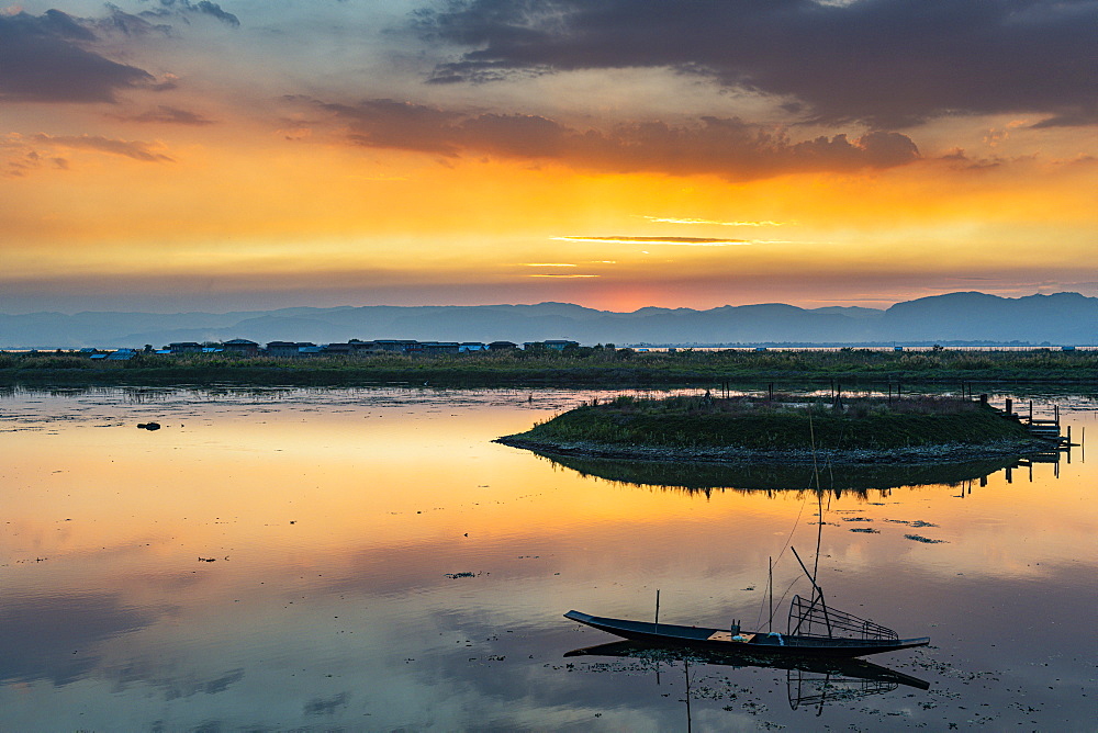 Clouds and traditional rowing boat reflecting in the water at sunset, Inle Lake, Shan state, Myanmar (Burma), Asia