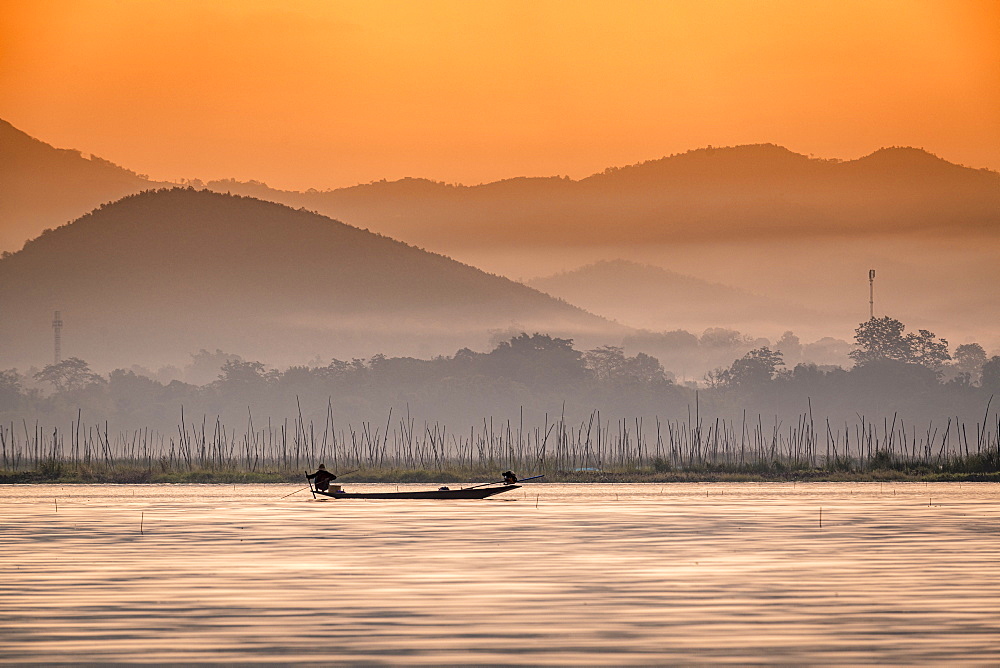 Young fisherman with net at sunrise, Inle Lake, Shan state, Myanmar (Burma), Asia