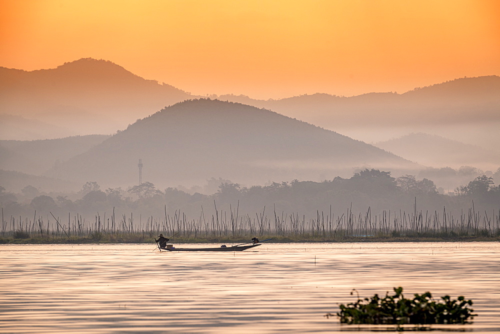 Young fisherman with net at sunrise, Inle Lake, Shan state, Myanmar (Burma), Asia