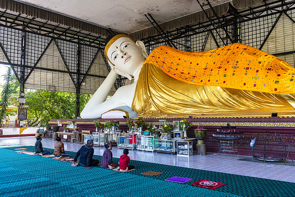 Pilgrims praying before a reclining Buddha, Su Taung Pyi pagoda, Myitkyina, Kachin state, Myanmar (Burma), Asia